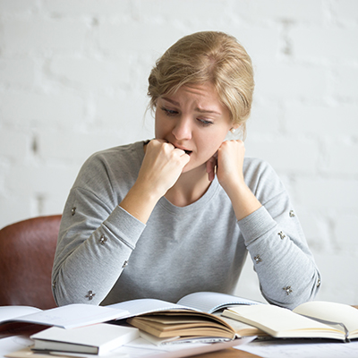 women stressed with papers on desk